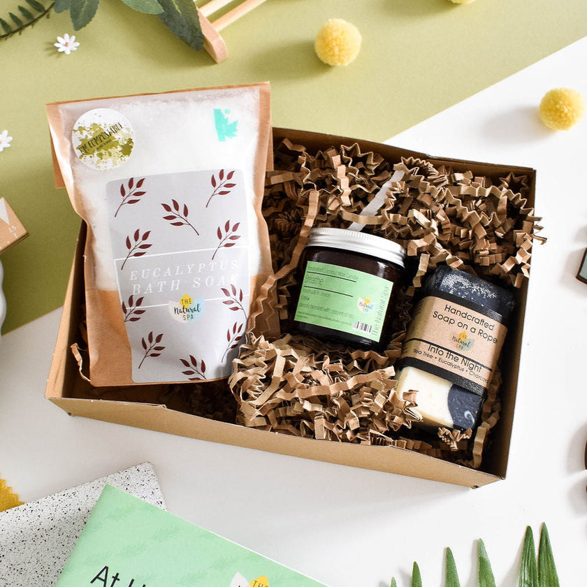 Breathe At Home Spa Set with eucalyptus, rosemary, and peppermint bath and body products arranged with natural elements