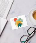 Colourful Elephant Trio rectangular acrylic ornament, green yellow and teal elephants beneath a red sun, red hanging ribbon – view 3