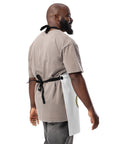 Plain reverse of the white Chicken on a Bicycle kitchen apron, showing black twill ties and fasteners
