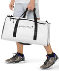 Travel More Worry Less white 50 litre duffle bag with black handles and strap – front lifestyle view