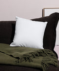 Love in Every Language 18-inch premium white pillow with large black multilingual typography – back lifestyle view