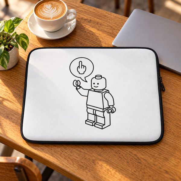 White brick figure laptop sleeve on a sunlit oak café table beside a silver laptop, coffee and green plant.