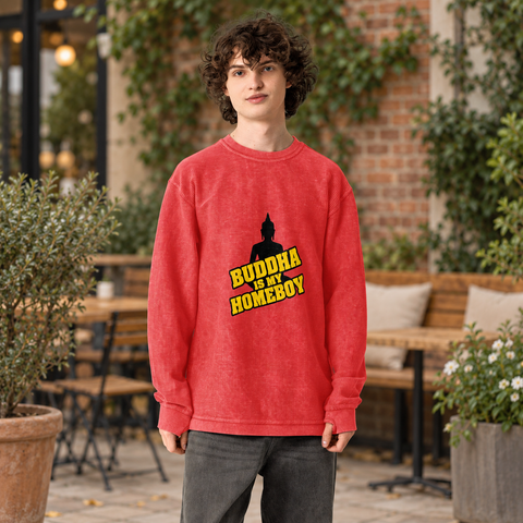 Model wearing the red Buddha Is My Homeboy oversized cord sweatshirt on a leafy cafe terrace, showing its single black and yellow front print.
