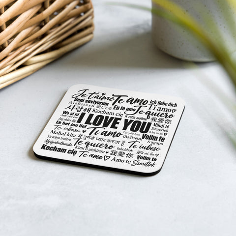 Love in Every Language coaster on a pale stone tabletop beside a woven basket and greenery.