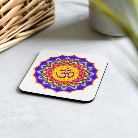 Psychedelic Om Lotus glossy cork-back coaster on a pale stone surface beside a woven basket and green plant, showing one complete colourful lotus mandala with an Om symbol.