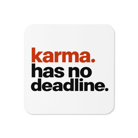 White square cork-back coaster with rounded corners and the original karma. has no deadline. design in rust-orange and black lettering.