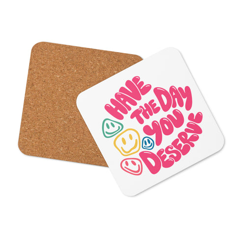 Glossy white cork-back coaster with original pink Have the Day You Deserve lettering and colourful smiley faces centred in full – ZIPZAPPA