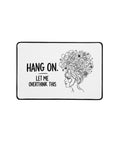 Front view of the compact white Overthink This desk mat with black lettering, a tangled-thoughts illustration and black hemmed edges.