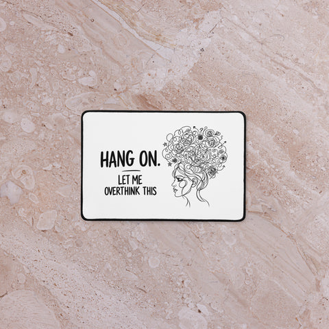 White Overthink This desk mat on a pale marble surface, viewed from above.