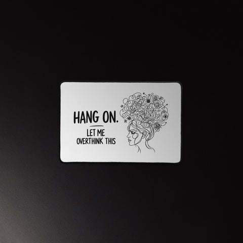 White Overthink This desk mat beneath a mouse and keyboard on a dark desk.