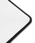 Close-up of the white polyester surface and black hemmed corner of the Overthink This desk mat.
