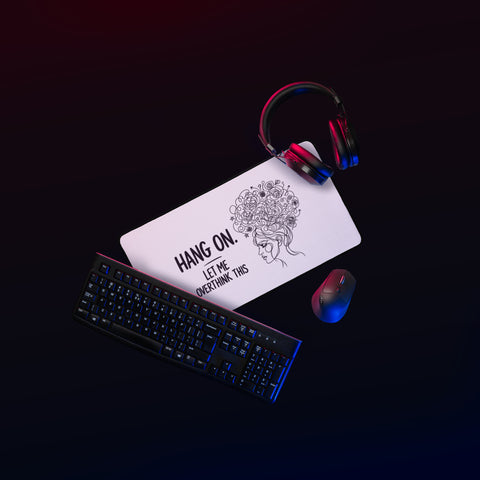 Medium white Overthink This desk mat on a gaming desk beside a mouse and headphones.