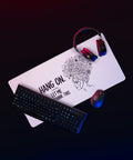 Large white Overthink This desk mat on a gaming desk beside a mouse and headphones.