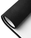 Rolled large Overthink This desk mat showing its unprinted black rubber underside.