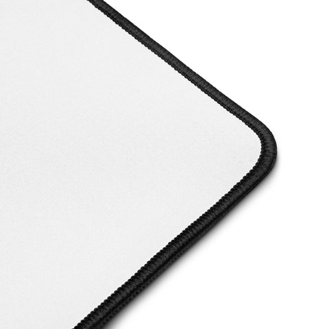 Close-up of the large Overthink This desk mat showing its white surface and black hemmed corner.