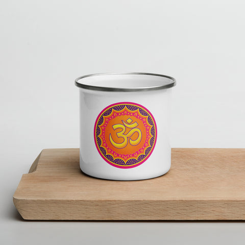 White 12 oz enamel mug with a silver rim and a pink, purple and golden-orange Om mandala on the front, shown on a wooden board; front view.