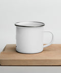 White 12 oz enamel mug with a silver rim and original Find Yourself black figure and red map-pin artwork – ZIPZAPPA