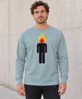 Male model wearing an Agave heavyweight long-sleeve tee with a black human figure and yellow, orange and red flame head, standing by a pale concrete wall.