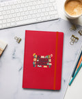 Red No Shelf Control hardcover lined notebook on a pale marble desk beside a white keyboard, coffee, pencils and binder clips, showing one complete bookish front-cover design.