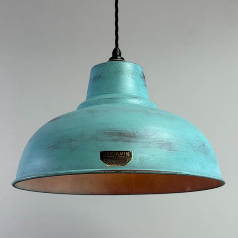 Turquoise pendant light with a brand logo on a gray background