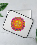 Vibrant Om Mandala 13-inch laptop sleeve with one complete colourful front print and black zipper trim on a pale stone desk beside a silver laptop and green leaves.