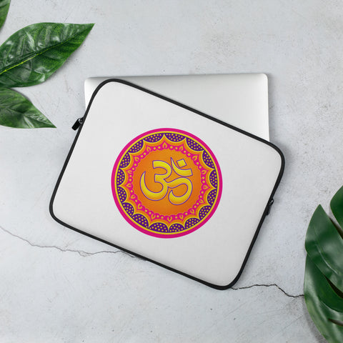 Vibrant Om Mandala 13-inch laptop sleeve with one complete colourful front print and black zipper trim on a pale stone desk beside a silver laptop and green leaves.