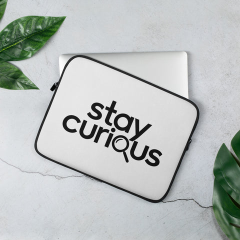 White 13-inch laptop sleeve with original Stay Curious magnifying-glass wordmark on the front – mockup 2 – ZIPZAPPA