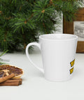 Left-side view of a white Buddha Is My Homeboy latte mug beside pastries and green branches.