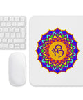 White mouse pad with a purple, turquoise, green, orange and yellow Om lotus mandala centred on the top.