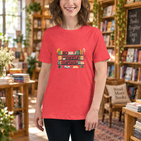 Model wearing the Heather Red No Shelf Control women’s relaxed tee in a sunlit bookstore with wooden shelves and plants, showing one complete book-themed front print.