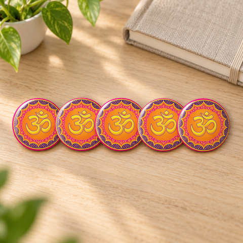 Five matching Vibrant Om Mandala 1.25-inch glossy pin buttons on a pale oak desk beside a linen notebook and green plant, each showing one complete colourful Om front design.