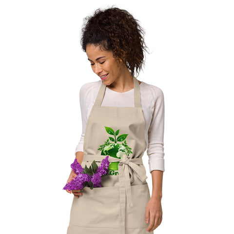 Woman wearing a Rope organic cotton apron with green leafy Earth artwork and Go Green lettering above a two-compartment pocket.
