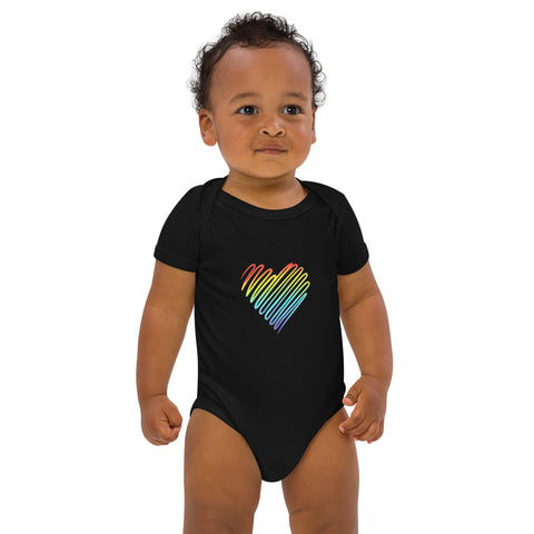 Baby modelling the black Rainbow Heart organic cotton bodysuit, viewed from the front.