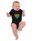 Baby lying down in the black Rainbow Heart organic cotton bodysuit.
