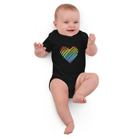 Baby lying down in the black Rainbow Heart organic cotton bodysuit.