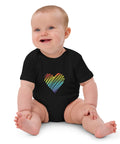 Seated baby wearing the black Rainbow Heart organic cotton bodysuit.