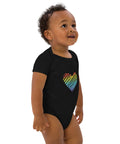 Side view of a baby wearing the black Rainbow Heart organic cotton bodysuit.