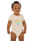 Baby modelling the organic natural Rainbow Heart organic cotton bodysuit, viewed from the front.