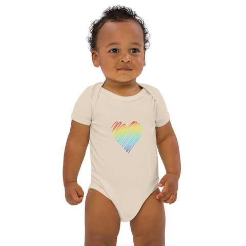 Baby modelling the organic natural Rainbow Heart organic cotton bodysuit, viewed from the front.