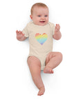 Baby lying down in the organic natural Rainbow Heart organic cotton bodysuit.
