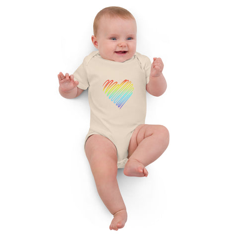 Baby lying down in the organic natural Rainbow Heart organic cotton bodysuit.