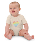 Seated baby wearing the organic natural Rainbow Heart organic cotton bodysuit.