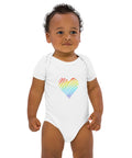 Baby modelling the white Rainbow Heart organic cotton bodysuit, viewed from the front.