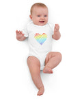 Baby lying down in the white Rainbow Heart organic cotton bodysuit.