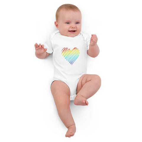 Baby lying down in the white Rainbow Heart organic cotton bodysuit.