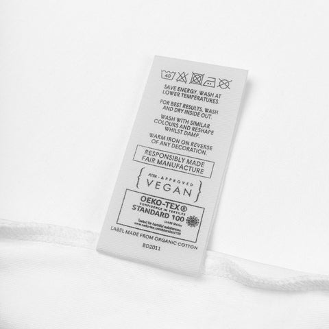 Fabric label detail on the white Rainbow Heart organic cotton bodysuit.
