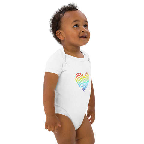 Side view of a baby wearing the white Rainbow Heart organic cotton bodysuit.