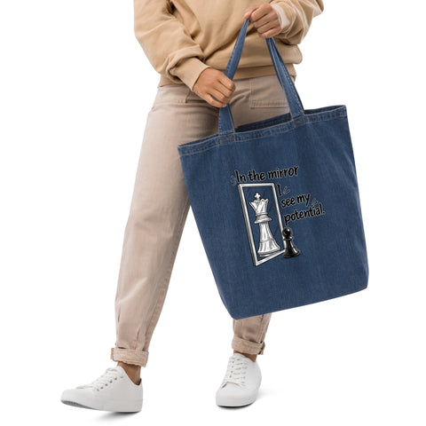 In the Mirror I See Potential organic denim-blue tote bag with large chess pawn and king illustration – front lifestyle view