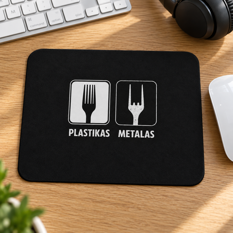 Black Plastikas / Metalas fork humour mouse pad on an oak desk beside a white mouse, keyboard and headphones.