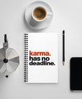 White spiral notebook with rust-orange and black Karma Has No Deadline lettering centred on the front cover – ZIPZAPPA